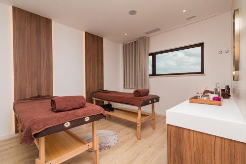 a treatment room with two beds and a window at Haven Nature Hotel & Villas in Batalha