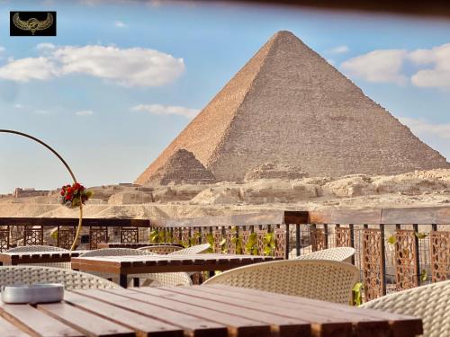 a view of the pyramids of giza with tables and chairs at Comfort Inn Pyramids Hotel in Cairo