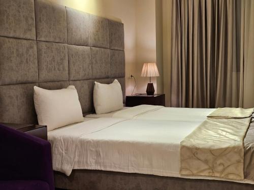 a bedroom with a large bed with white pillows at Crown Suites in Baku