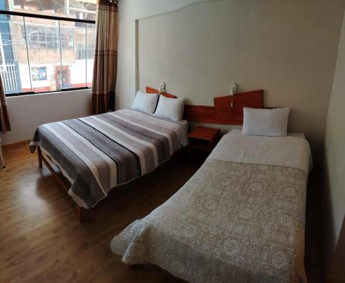 a hotel room with two beds and a window at Nayras Puno Hotel in Puno