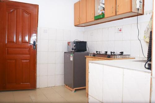 J and A Haven BnB- Langata Road opposite Uhuru gardens memorial park في نيروبي: مطبخ صغير مع ثلاجة ومغسلة