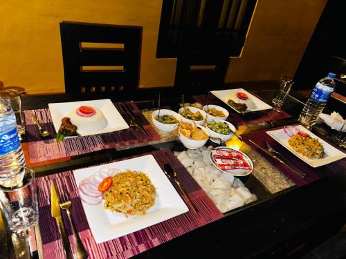 a table with several plates of food on it at Ceylon Safari Cottage in Udawalawe