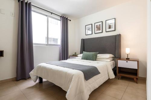 a bedroom with a large bed and a window at Depto moderno cerca Estadio GNP y Aeropuerto in Mexico City