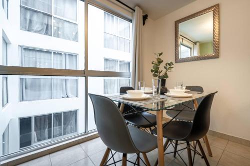 a dining room with a table and chairs and a mirror at Depto moderno cerca Estadio GNP y Aeropuerto in Mexico City
