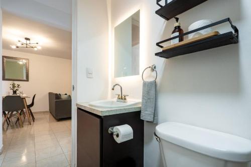 a bathroom with a sink and a toilet and a mirror at Depto moderno cerca Estadio GNP y Aeropuerto in Mexico City
