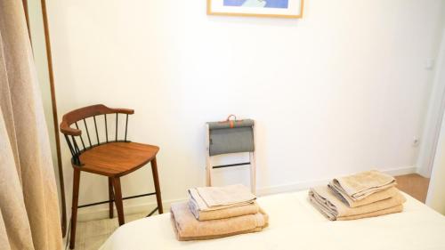 a room with a table with a chair and towels at Kalumi in Vila Nova de Milfontes