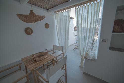een eetkamer met een houten tafel en stoelen bij PugliAlcove in Castellana Grotte