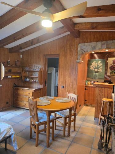 a kitchen with a wooden table and chairs at Can Marisu in Cabrils