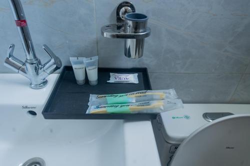- un lavabo avec des brosses à dents et du dentifrice dans l'établissement Hotel Yatri Niwas, à Dhungrebās