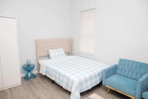 Un dormitorio con una cama y una silla azul. en Brighton Beach Retreat Blue30, en Brooklyn