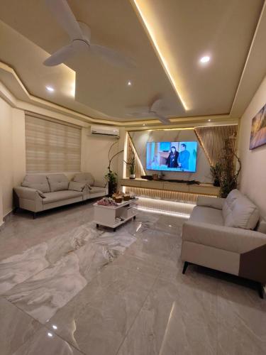 a living room with couches and a flat screen tv at ROYAL VILLAGE inn Dhangethi Maldives in Dhangethi