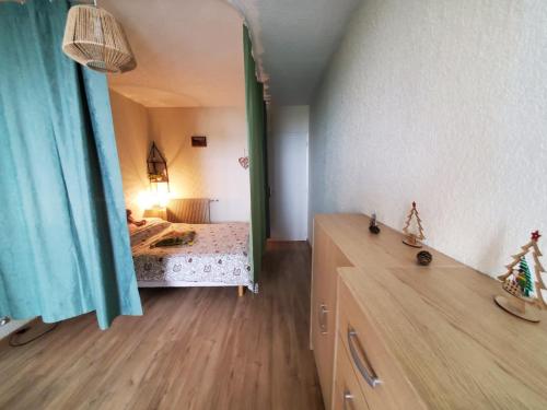 a room with a bedroom with a bed and a mirror at Bel appartement spacieux 44m² à SUPER BESSE pour 6 personnes in Super Besse