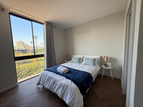 a bedroom with a bed and a large window at Luxe 1br apartment on Park in Cape Town