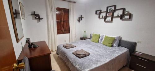 a bedroom with a bed with green pillows on it at Tres Playas Apartment in Puerto de Mazarrón