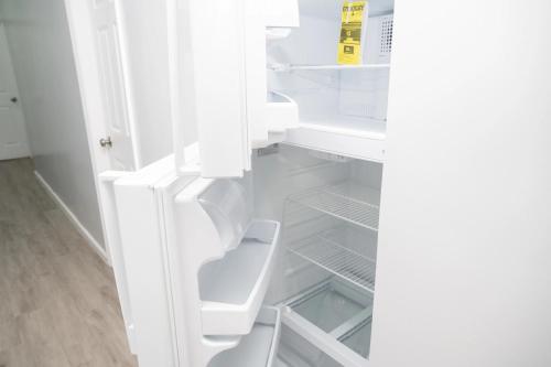 una nevera blanca con la puerta abierta en una habitación en Brighton Beach Retreat Blue30, en Brooklyn