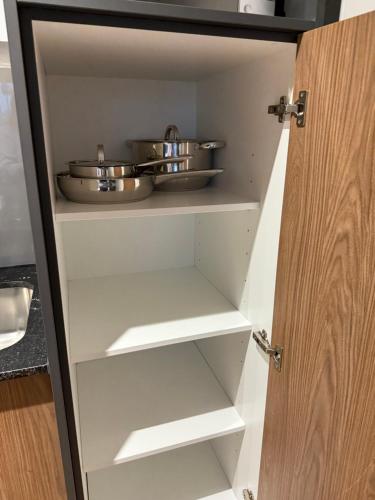 a cupboard with two pots and pans in it at Luxe 1br apartment on Park in Cape Town