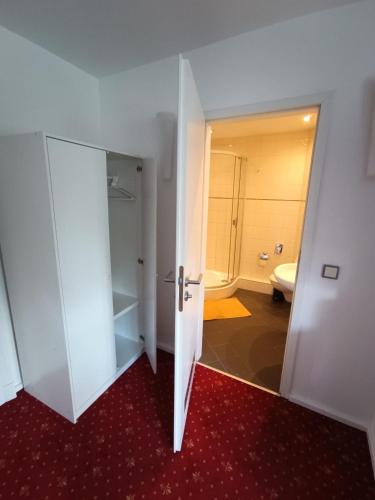 an open door to a bathroom with a toilet at Die Villa Hotel in Leverkusen