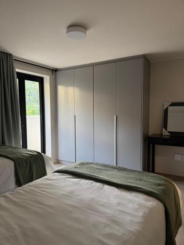 a bedroom with a bed and a tv and cabinets at Marina Views Simon's Town in Simonʼs Town