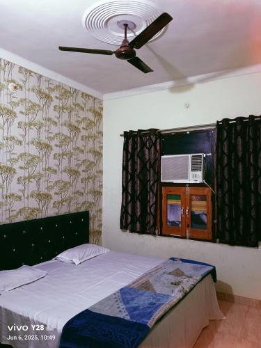 a bedroom with a bed and a ceiling fan at RAJWADA Hotel in Gangānagar