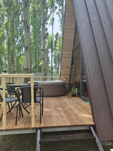 a house with a deck with a table and chairs at Zovaber hangsti goti in Sevan