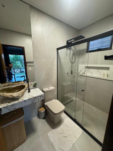a bathroom with a toilet and a glass shower at Casa Aloha in Petrolina