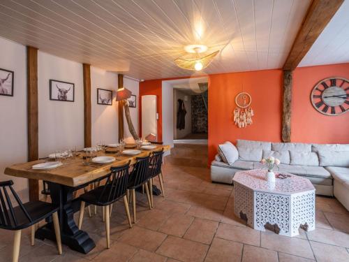 ein Esszimmer mit Tisch und Couch in der Unterkunft Maison auvergnate cœur de village in Messeix