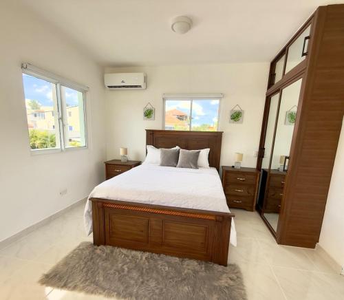 a bedroom with a large bed and two windows at Apartamento acogedor con cocina y balcón privado in Bayahibe