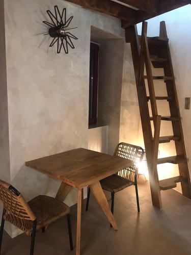 a wooden table and chairs in a room with a staircase at Evanthia maisonette in Chalkida