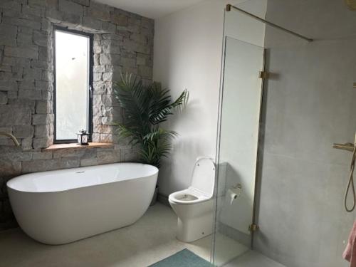 a bathroom with a tub and a toilet and a window at Bective Views in Bective
