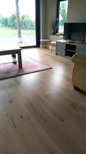 a living room with a wooden floor and a couch at Bective Views in Bective