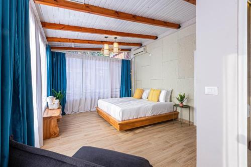 a bedroom with a bed in a room with blue curtains at Dhermi's Icon - Penthouse 2BR, 2wc - Premium VIEWS 16 in Dhërmi