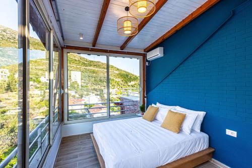a bed in a room with a blue wall at Dhermi's Icon - Penthouse 2BR, 2wc - Premium VIEWS 16 in Dhërmi