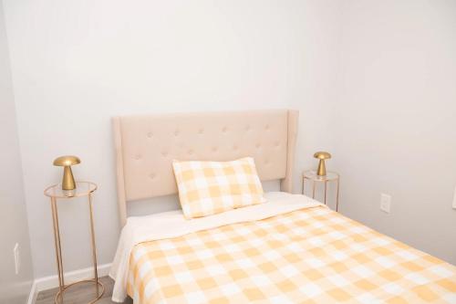 a bed with a checkered blanket and two lamps at Beachh - 2Beach House - Yellow3090 in Brooklyn