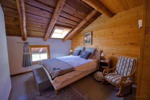 a bedroom with a bed and a chair in a cabin at Les Mayens in Leysin