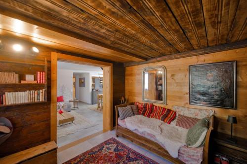 a living room with a couch and wooden walls at Les Mayens in Leysin