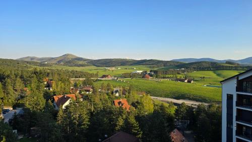 a small town in a valley with trees and mountains at Apartman Harmonija Rent Zlatibor in Zlatibor