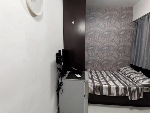 a small bed in a room with a wall at Love's nest in Hong Kong
