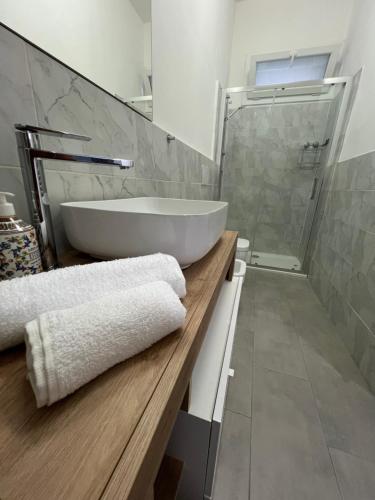 ein Badezimmer mit einem großen weißen Waschbecken und einer Dusche in der Unterkunft Casa gioiello al mare Cogoleto in Cogoleto