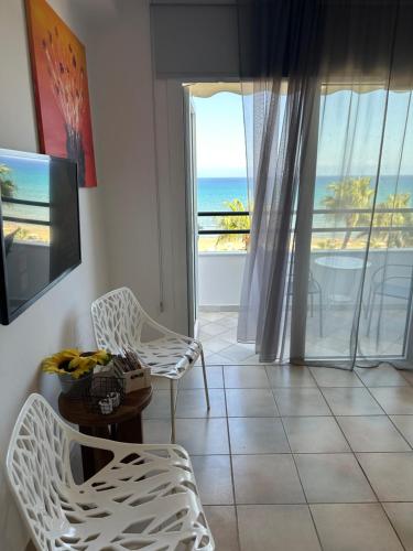 a living room with a table and chairs and a view of the ocean at Krasas Beach in Larnaka