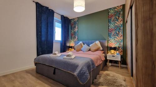 a bedroom with a large bed with a purple blanket at Albert Garden Retreat in Ploieşti