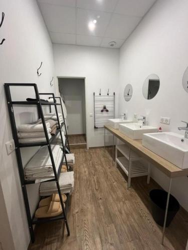 a bathroom with two sinks and a shelf with towels at The Corner Pavillon in Noirmoutier-en-l'lle
