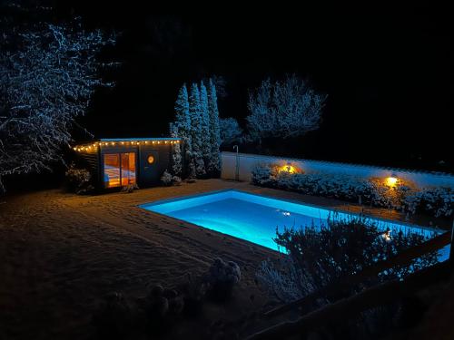 a swimming pool in front of a house at night at Cozy & Private Luxury Guesthouse, 30 min from Copenhagen in Stenløse