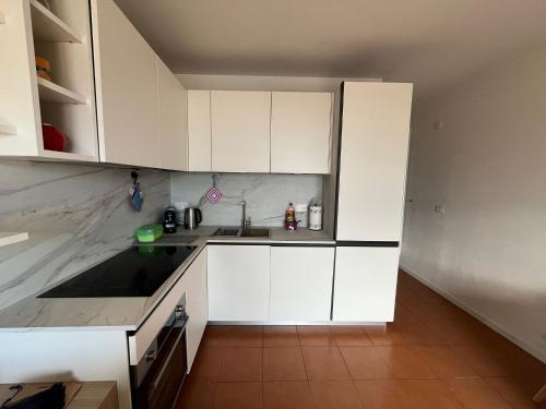 a kitchen with white cabinets and a sink at La casa sul lago blu in Domaso