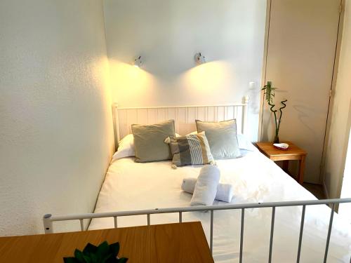 a bedroom with a bed with white sheets and pillows at Le Chamois 5E Balcon panoramique MontBlanc avec parking gratuit in Chamonix-Mont-Blanc