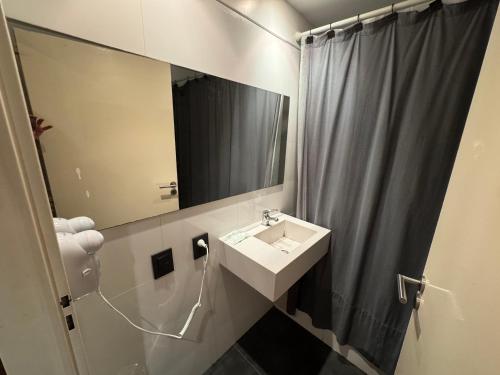 a bathroom with a sink and a shower curtain at Apart Tonico in Buenos Aires