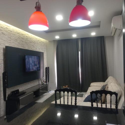 Una sala de estar con dos sillas y un sofá. en Aliguedes, en Luanda