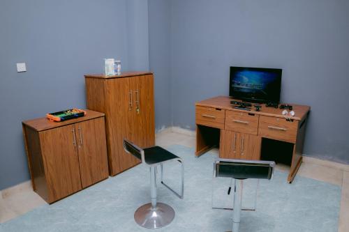 a room with a desk with a tv and two chairs at Olympus Plaza Hotel in Haputale