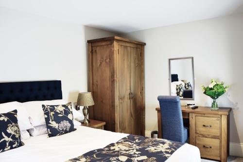 a bedroom with a bed and a desk with a blue chair at The Morecambe Hotel in Morecambe