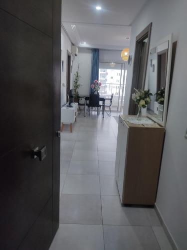 a hallway with a door and a room with a table at Magnifique appartement avec vue dégagée, près de l'aéroport et parking privé in Ariana