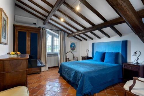 a bedroom with a blue bed in a room at Villa Orange Rome in Castel di Leva